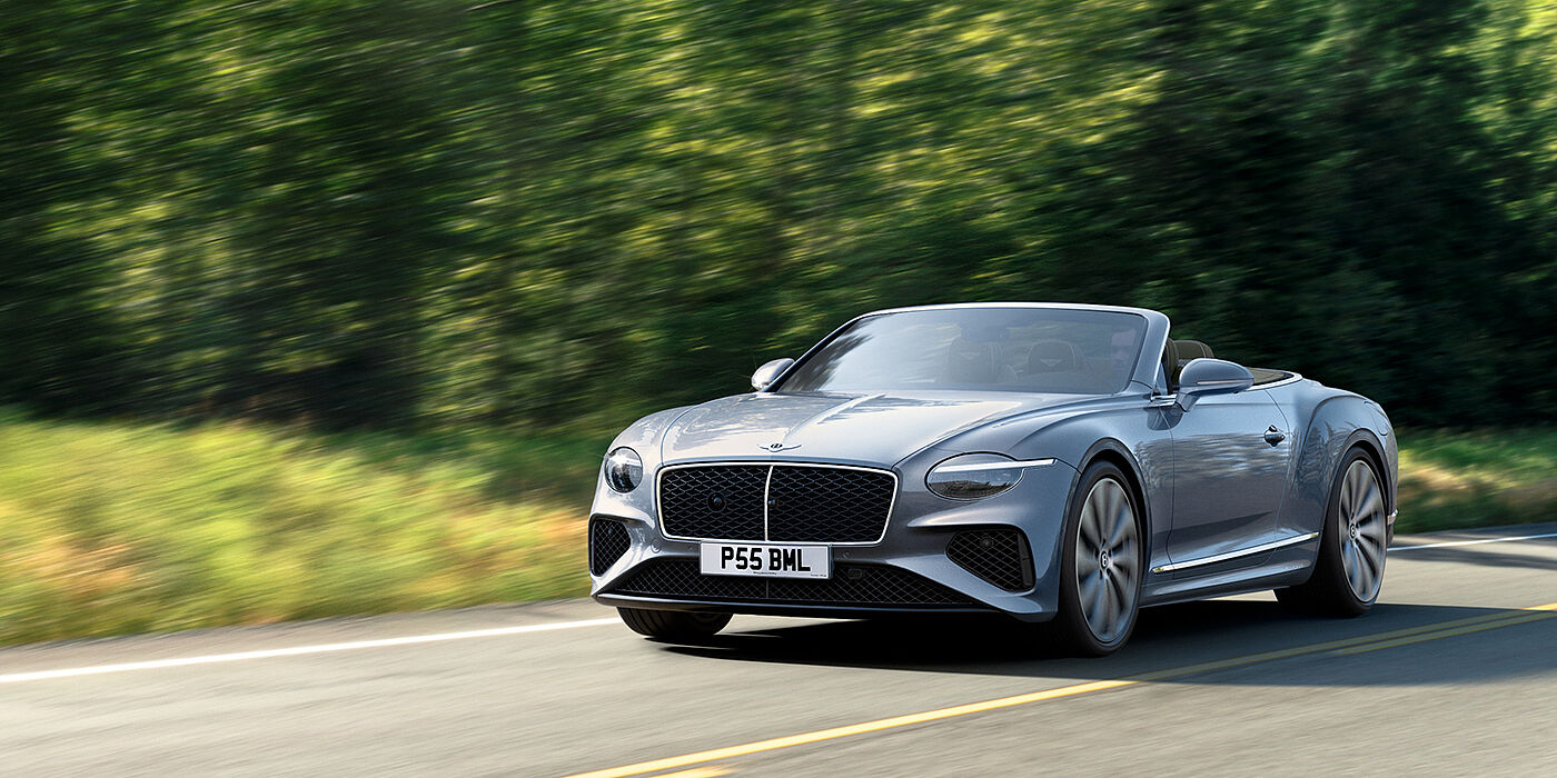 Bentley Manchester New Bentley Continental GTC convertible front view in Silverlake paint with 22 inch ten spoke wheels, driving dynamically on a country road